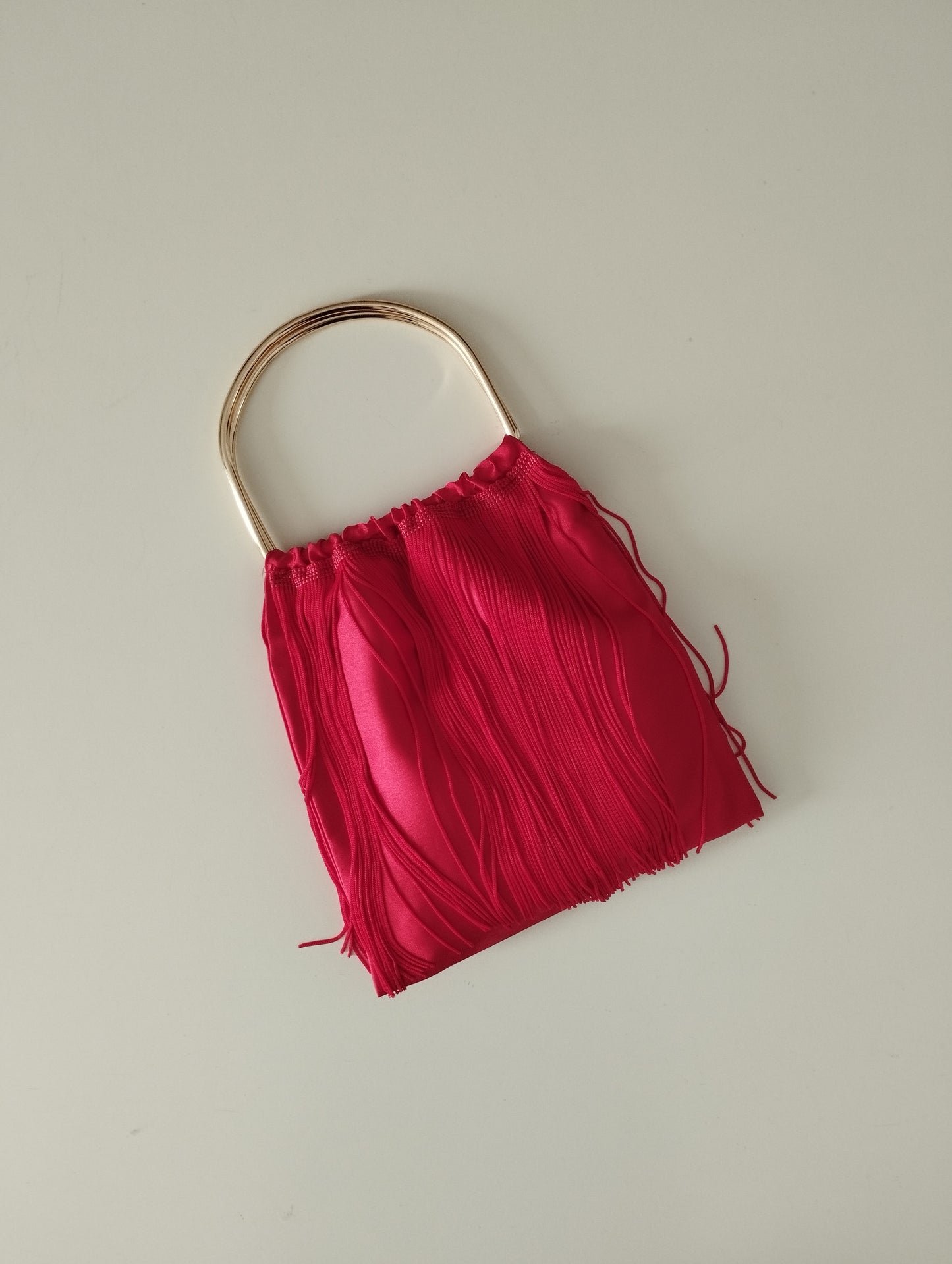 Borsa a sacchetto con frangia di nappe e manico in metallo